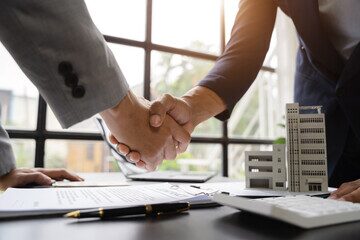 Close up shake hands, Considering buying a home, investing in real estate. Broker signs a sales agreement. agent, lease agreement, successful deal.